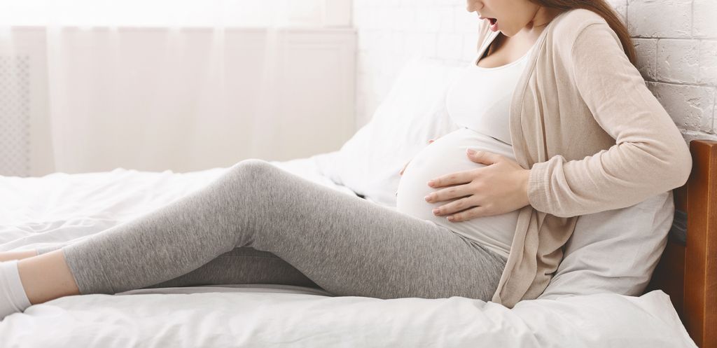 Premature birth. Pregnant woman suffering from contractions at home, panorama, free space