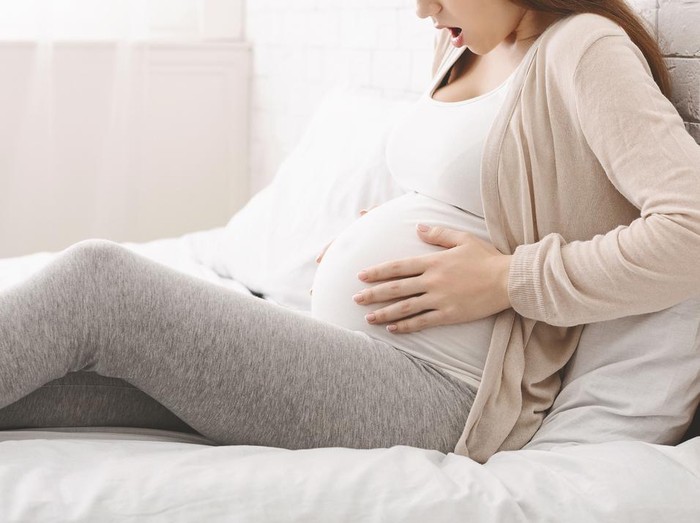 1207713786 Premature birth. Pregnant woman suffering from contractions at home, panorama, free space