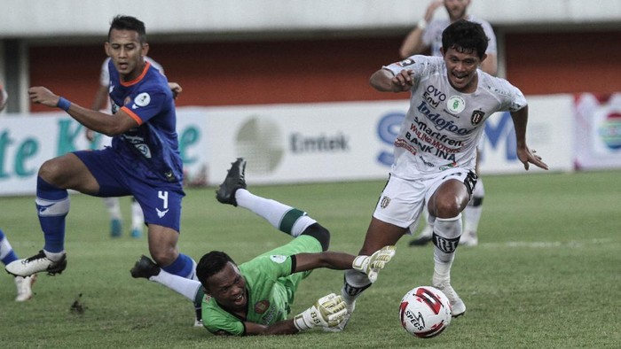 Pesepak bola Bali United Rizky Ahmad Sanjaya Pellu (kanan) mencoba melewati penjaga gawang Persiraja Banda Aceh Fakrurrazi (kiri) saat pertandingan Piala Menpora di Stadion Maguwoharjo, Sleman, DI Yogyakarta, Senin (29/3/2021). ANTARA FOTO/Hendra Nurdiyanyah/rwa.