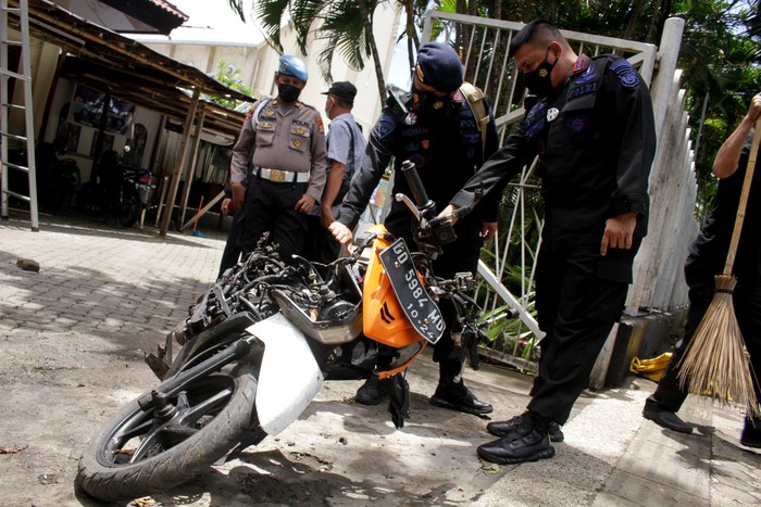 Anggota polisi mengamati motor yang digunakan terduga pelaku bom bunuh diri sebelum dievakuasi di depan Gereja Katedral Makassar, Sulawesi Selatan, Senin (29/3/2021). Kepolisian telah mengidentifikasi salah satu dari dua terduga pelaku bom bunuh diri yang terjadi pada Minggu (28/3/2021) di depan Gereja Katedral Makassa rberjenis kelamin laki-laki berinisial L sedangkan lainnya masih dalam proses identifikasi. ANTARA FOTO/Arnas Padda/yu/aww.
