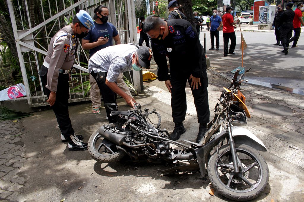 Anggota polisi mengamati motor yang digunakan terduga pelaku bom bunuh diri sebelum dievakuasi di depan Gereja Katedral Makassar, Sulawesi Selatan, Senin (29/3/2021). Kepolisian telah mengidentifikasi salah satu dari dua terduga pelaku bom bunuh diri yang terjadi pada Minggu (28/3/2021) di depan Gereja Katedral Makassa rberjenis kelamin laki-laki berinisial L sedangkan lainnya masih dalam proses identifikasi. ANTARA FOTO/Arnas Padda/yu/aww.