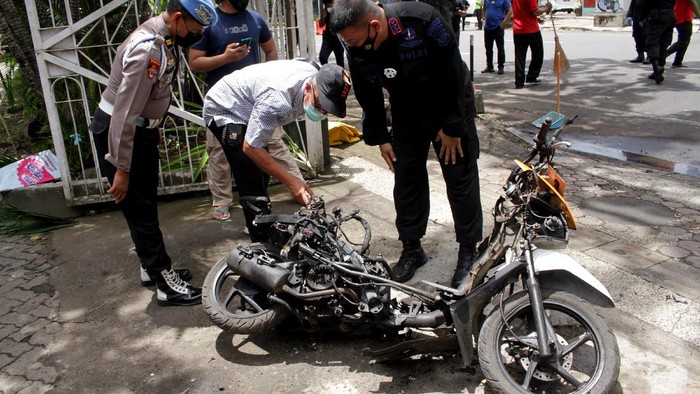 Anggota polisi mengamati motor yang digunakan terduga pelaku bom bunuh diri sebelum dievakuasi di depan Gereja Katedral Makassar, Sulawesi Selatan, Senin (29/3/2021). Kepolisian telah mengidentifikasi salah satu dari dua terduga pelaku bom bunuh diri yang terjadi pada Minggu (28/3/2021) di depan Gereja Katedral Makassa rberjenis kelamin laki-laki berinisial L sedangkan lainnya masih dalam proses identifikasi. ANTARA FOTO/Arnas Padda/yu/aww.