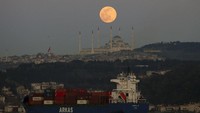 Bulan purnama terbit di atas langit di Istanbul, Minggu, 28 Maret 2021 dengan pemandangan Masjid Camlica, masjid terbesar di Asia Kecil. 