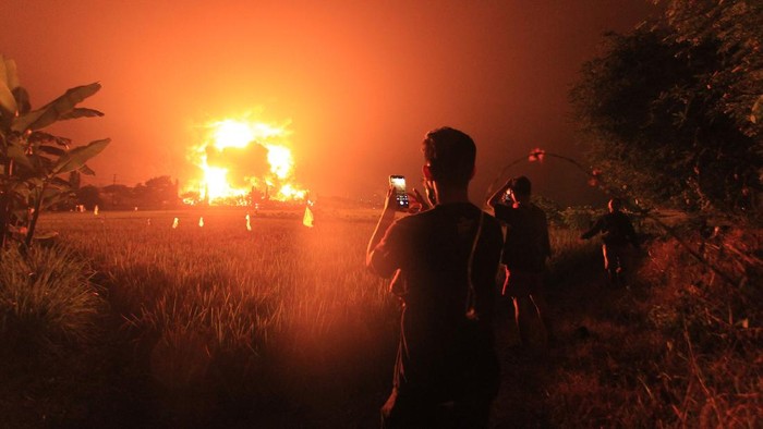 KEBAKARAN KILANG PERTAMINA BALONGAN Warga mengambil video dengan gawai miliknya saat terjadi kebakaran di kompleks Pertamina RU VI Balongan, Indramayu, Jawa Barat, Senin (29/3/2021) dini hari. ANTARA FOTO/Dedhez Anggara/pras.