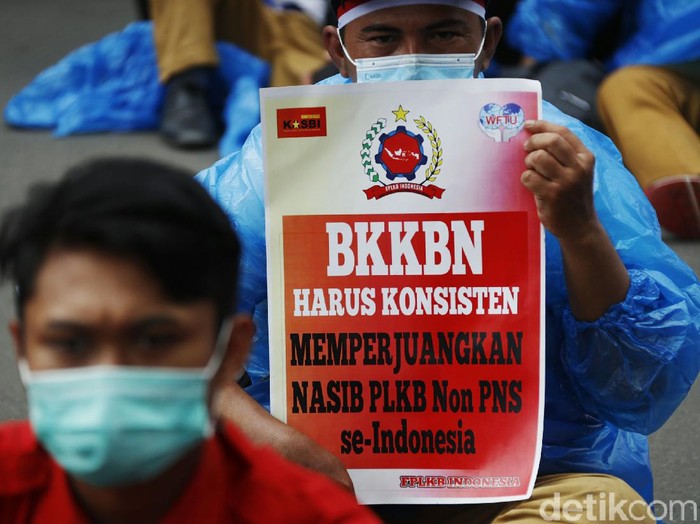 Dengan memakai jas hujan, sebanyak 600 anggota Federasi Petugas Lapangan Keluarga Berencana (FPLKB) melakukan aksi unjuk rasa menuntut pengangkatan menjadi pegawai negeri sipil (PNS), di Gedung Badan Kependudukan dan Keluarga Berencana Nasional (BKKBN), Halim Perdanakusuma, Jakarta, Senin (29/03/2021).
