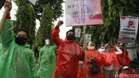 Dengan memakai jas hujan, sebanyak 600 anggota Federasi Petugas Lapangan Keluarga Berencana (FPLKB) melakukan aksi unjuk rasa menuntut pengangkatan menjadi pegawai negeri sipil (PNS), di Gedung Badan Kependudukan dan Keluarga Berencana Nasional (BKKBN), Halim Perdanakusuma, Jakarta, Senin (29/03/2021).  