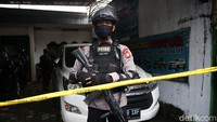 Polisi bersenjata laras panjang menjaga ketat showroom mobil yang menjadi lokasi pengerebekan terduka teroris di Condet, Jakarta, Senin (29/3/2021).