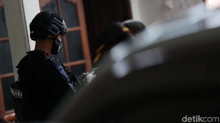 Polisi memasang garis polisi saat pengerebekan di Showroom Mobil Kemilau Motor, Condet, Jakarta, Senin (29/3/2021). Polisi menggerebek showroom mobil ini terkait terorisme.