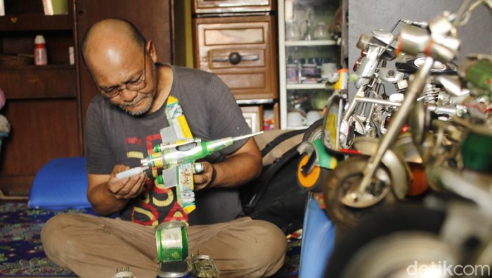 Ade Syarifudin tengah membuat miniatur di rumahnya.