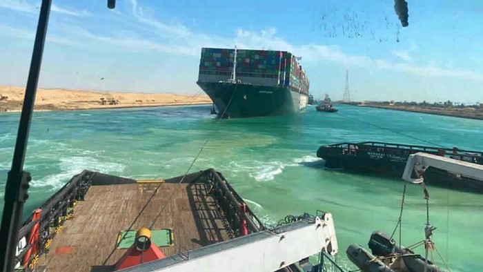 In this photo released by Suez Canal Authority, the Ever Given, a Panama-flagged cargo ship is accompanied by Suez Canal tugboats as it moves in the Suez Canal, Egypt, Monday, March 29, 2021. Salvage teams on Monday set free a colossal container ship that has halted global trade through the Suez Canal, bringing an end to a crisis that for nearly a week had clogged one of the world's most vital maritime arteries. (Suez Canal Authority via AP)