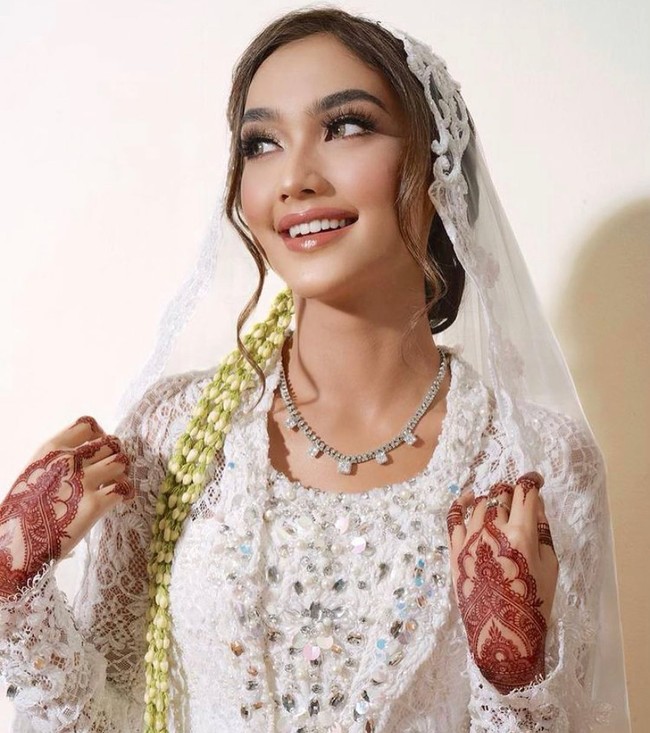 Syafira Haddad, selebriti TikTok yang kini eksis bermain film ini juga memakai henna saat acara akad nikah dan resepsi. Ia memakai kebaya putih dengan veil wedding transparan. Foto: Dok.Instagram @barbie_ima.