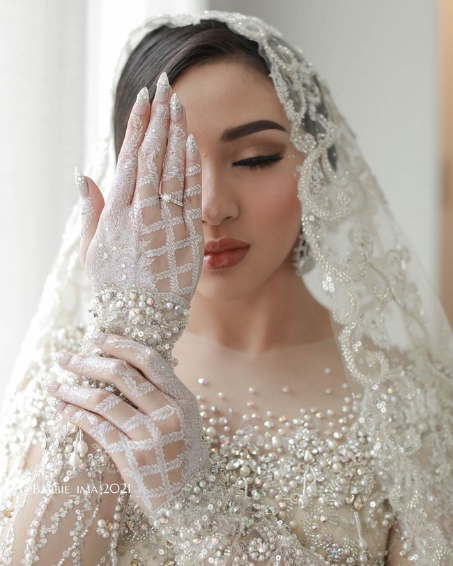 Margin Theresia Winaya Hermawan, atau lebih dikenal sebagai Margin Wieheerm Khan menikah dengan Ali Syakieb pada 6 Februari 2021. Saat acara pernikahan, ia meminta desain white henna dengan starlit powder dan Real Crystal Swarovski element yang shinny dan mewah. Margin request whitehenna yang agak penuh tapi nggak too much, dan nail art cutting Stiletto silver ombre bertabur real crystal swarovski. Cantik banget, indah dan elegant sesuai dengan tema wedding, tutur @barbie_ima selaku pelukis henna Margin. Foto: Dok.Instagram @barbie_ima.