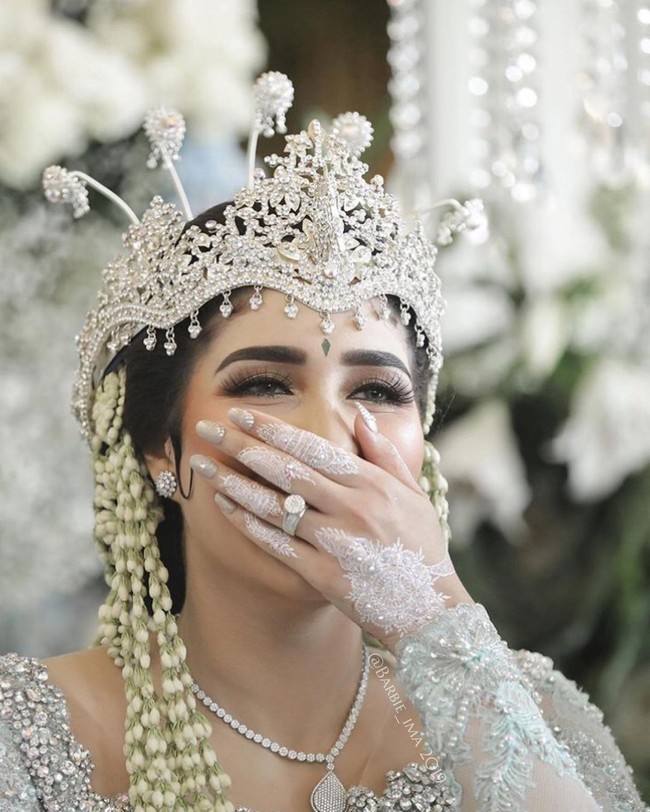 Fatimah Tania Nadira merupakan mantan istri Tommy Kurniawan. Keduanya resmi bercerai pada tahun 2017. Kini Tania telah menikah dengan Abdullah Alwi pada tahun 2019 lalu. Saat acara pernikahan ia tampak memakai siger Sunda dengan riasan white henna yang simpel dan elegan. Foto: Dok.Instagram @barbie_ima.