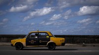 Sebuah taksi Lada era Soviet mengemudi di sepanjang Malecon yang berada di kawasan Kuba. Tak sedikit mobil Lada yang dirombak menjadi taksi di negara yang pernah dipimpin oleh Fidel Castro itu.