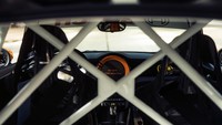 Mobil ini mempertahankan beberapa hal penting seperti jok depan yang dilengkapi safety belt dengan tali pengaman enam titik.  Untuk pengemudi, terdapat cluster instrumen digital dan setir serat karbon, tetapi tampilan tengah telah diganti dengan penutup serat karbon untuk menghemat bobot. Foto: Dok. MINI