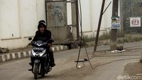 Selain itu, tampak pula kabel menjuntai di area jalan.