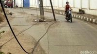 Sejumlah kabel yang terurai di tengah jalan itu membuat pengendara harus ekstra hati-hati saat melintasi jalan tersebut.