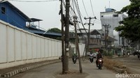 Sejumlah pengendara melintas di samping tiang yang berada di tengah Jalan Perancis, Kosambi, Tangerang, Selasa (30/3/2021).