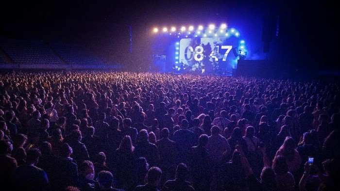 People take part in a music concert in Barcelona, Spain, Saturday, March 27, 2021. Five thousand music lovers are set to attend a rock concert in Barcelona on Saturday after passing a same-day COVID-19 screening to test its effectiveness in preventing outbreaks of the virus at large cultural events. The show by Spanish rock group Love of Lesbian has the special permission of Spanish health authorities. While the rest of the country is limited to gatherings of no more than four people in closed spaces, the concertgoers will be able to mix freely while wearing face masks. (AP Photo/Emilio Morenatti)