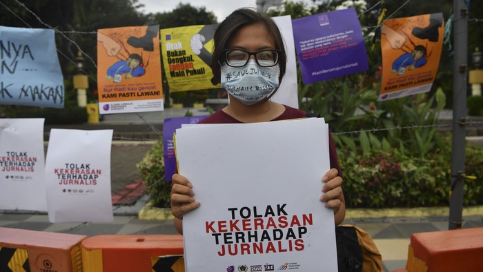 Wartawan yang tergabung dalam Forum Jurnalis se-Surabaya membentangkan poster ketika aksi solidaritas jurnalis di Surabaya, Jawa Timur, Senin (29/3/2021). Dalam aksinya, mereka mendesak agar kepolisian mengusut tuntas kasus kekerasan yang diduga dilakukan oknum aparat  terhadap wartawan Tempo Nurhadi  ketika melakukan peliputan terkait kasus dugaan suap pajak Angin Prayitno Aji, mantan Direktur Pemeriksaan Direktorat Jenderal Pajak Kementerian Keuangan. ANTARA FOTO/Zabur Karuru/aww.