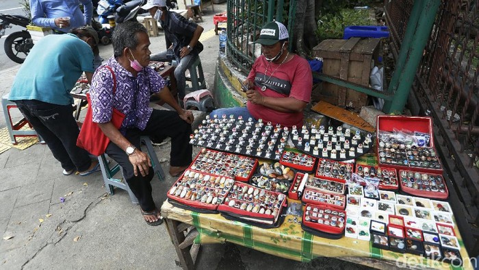 Sepi pembeli, para pedagang batu akik di Jalan Rawa Bunga, Jatinegara Timur, Jakarta, tetap bertahan berjualan dengan menggelar lapak mereka ditrotoar.