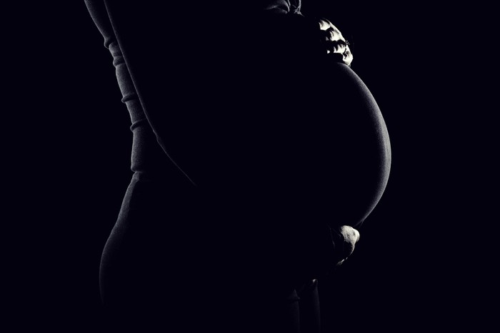 Low key portrait of a young womans pregnant belly.Image is processed from a 16 bit RAW file and profiled in ProPhoto RGB. All my images are professionally retouched.More from this Series: