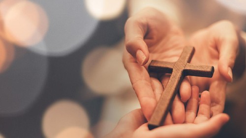 Empty tomb of Jesus at sunrise with crosses in background
