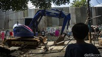 Alat berat bergerak untuk meratakan bangunan.