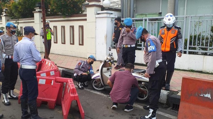 Petugas Dishun dan Polres Depok menggembok kendaraan yang parkir di dekat JPO Seberang Balai Kota Depok.