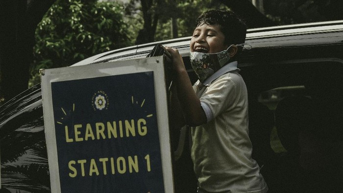 ADAPTASI SEKOLAH TATAP MUKA DENGAN METODE DRIVE IN Satu persatu mobil memasuki area parkir Padepokan Pencak Silat di kawasan TMII. Petugas keamanan pun turun tangan mengatur lalu lintas mobil yang datang untuk kegiatan belajar mengajar kelas satu dan tiga dari Sekolah Dasar Nizamia Andalusia School.