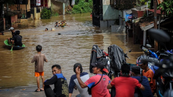 BANJIR LUAPAN SUNGAI CITARUM Warga menggunakan perahu melintasi banjir yang menggenangi permukiman di Andir, Baleendah, Kabupaten Bandung, Jawa Barat, Kamis (1/4/2021). Ratusan rumah di Kecamatan Dayeuhkolot dan Baleendah terdampak banjir luapan Sungai Citarum setinggi satu hingga satu setengah meter akibat intensitas hujan yang tinggi di Bandung raya pada Rabu (31/3) sore hingga malam hari. ANTARA FOTO/Raisan Al Farisi/hp.