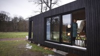 Seorang wisatawan melihat ke luar pintu geser dari Slow Cabin di Elewijt, Belgia.   