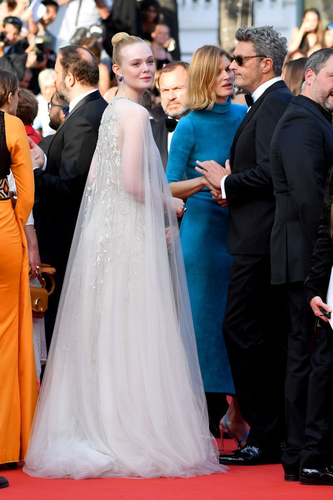 Elle Fanning bergaya bak putri ketika menghadiri Cannes Film Festival 2019. Gaun panjan dengan cape berbahan tulle nan dreamy ini datang dari kolekssi bridal Reem Acra. Foto: Pascal Le Segretain/Getty Images