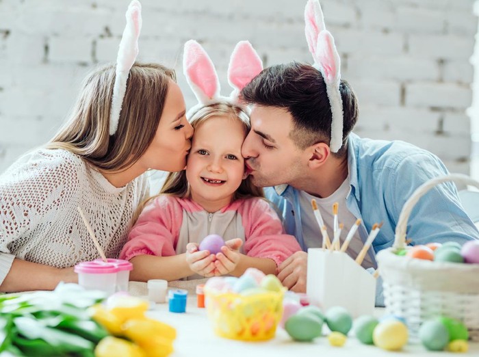 Lovely family paint easter eggs together.Happy little girl holding easter egg in hands.