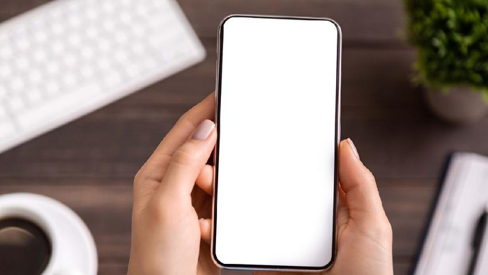 Woman demonstrating new modern smartphone with blank white screen for advertisement or application mockup