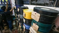Adul Salbini merapikan tumpukan film seluloid 35mm yang digunakan untuk layar tancap di Jakarta, Selasa (30/3/2021).