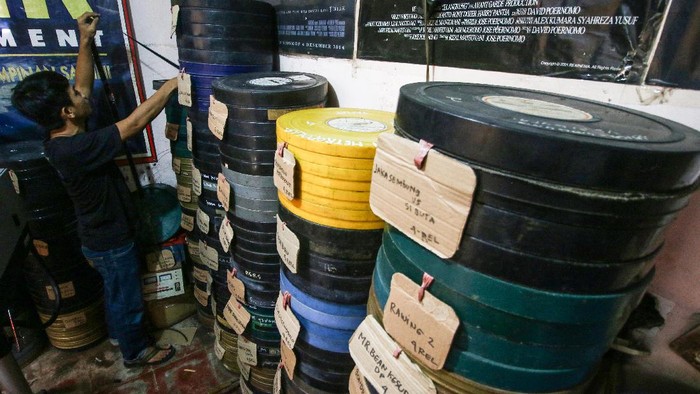 JASA PENYEWAAN FILM SELULOID MENURUN Adul Salbini memutar film seluloid 35mm yang digunakan untuk layar tancap di Jakarta, Selasa (30/3/2021). Ditengah masa pandemi COVID-19, jasa penyewaan film seluloid 35mm untuk layar tancap dengan harga Rp50 ribu sampai Rp200 ribu ini menurun hingga 80 persen. ANTARA FOTO/Rivan Awal Lingga/aww.