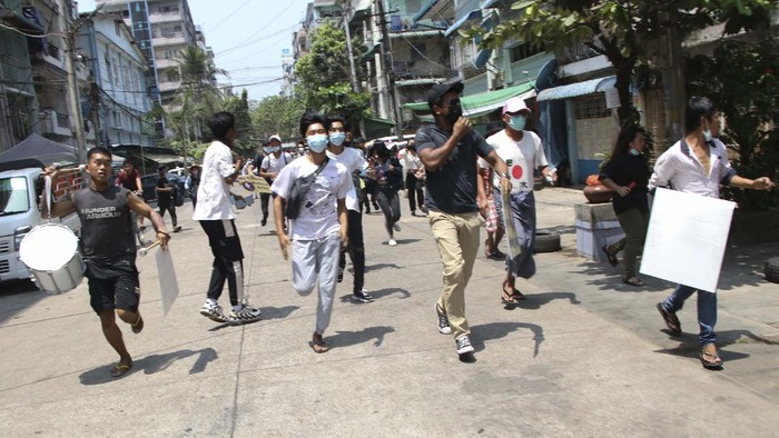 Anti-coup protesters run to avoid military forces during a demonstration in Yangon, Myanmar on Wednesday March 31, 2021. The Southeast Asian nation has been wracked by violence since the military ousted a civilian-led government on Feb. 1 and began to forcibly put down protests. (AP Photo)