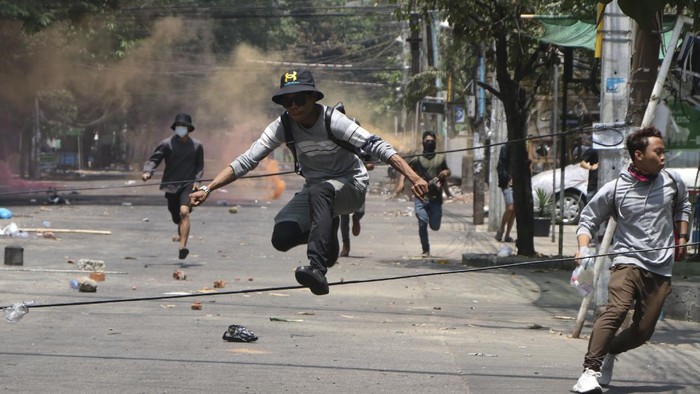 Korban Berjatuhan, Pendemo Myanmar Terus Beraksi Anti-coup protesters run to avoid military forces during a demonstration in Yangon, Myanmar on Wednesday March 31, 2021. The Southeast Asian nation has been wracked by violence since the military ousted a civilian-led government on February 1 and began to forcibly put down protests. (AP Photo)
