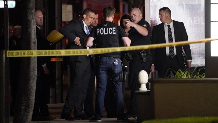 Investigators gather outside an office building where a shooting occurred in Orange, Calif., Wednesday, March 31, 2021. The shooting killed several people, including a child, and injured another person before police shot and wounded the suspect, police said. (AP Photo/Jae C. Hong)