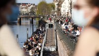 Kaum muda berkumpul di sepanjang tepi sungai Ill di Strasbourg, Prancis timur, Rabu (31/3/2021). AP Photo/Jean-Francois Badias  