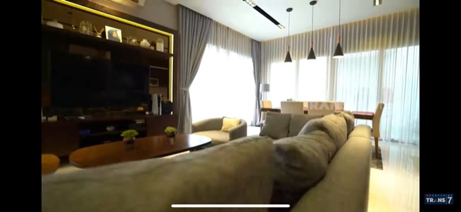 Interior bernuansa klasik-modern mendominasi di dalam rumah. Di ruang keluarga yang juga berfungsi sebagai ruang TV, terdapat sebuah sofa panjang abu-abu yang cozy. (Foto: Dok: YouTube/Trans7 Official)