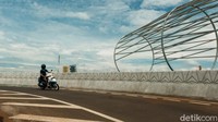 Aspal sudah terlihat mulus. Terlihat juga rambu lalu-lintas dan plang penunjuk jalan.