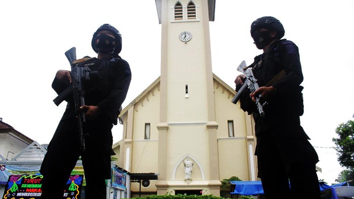 INDONESIA-BOMBINGS An Indonesian anti-bomb unit (C) collects evidences after a bomb exploded in Makassar on March 28, 2021. (Photo by IRVAN ABDULLAH / AFP)