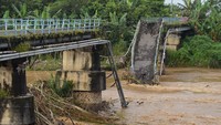 Warga melihat kondisi jembatan yang putus di Sungai Madiun, Kota Madiun, Jawa Timur, Jumat (2/4/2021). 