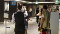 Para penumpang diukur suhu tubuhnya saat memasuki restoran kapal pesiar MSC Grandiosa di Civitavecchia.