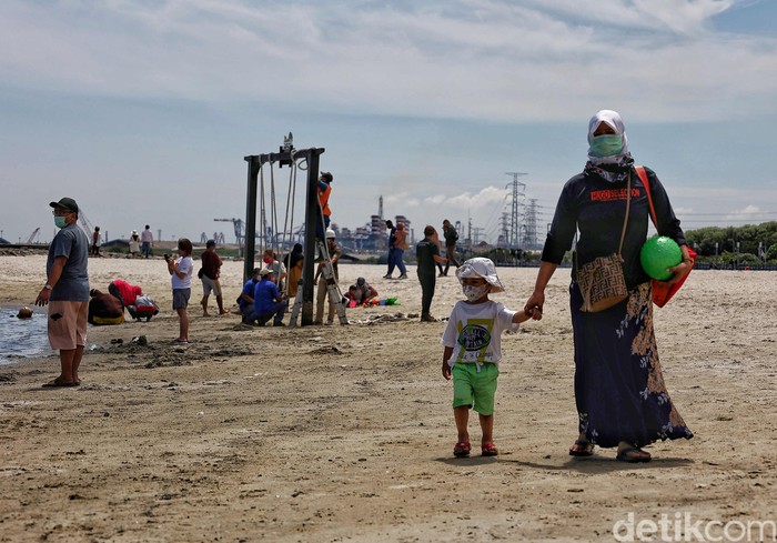 Sejumlah pengunjung menikmati Pantai Ancol, Jakarta Utara, Jumat (2/4).