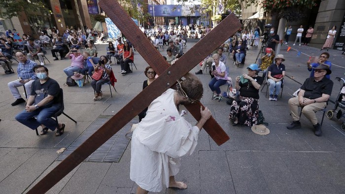 Melihat Prosesi Jalan Salib di Australia Actor Timothy Watkins carries a cross during his portrayal of Jesus Christ in a reenactment of the Journey to the Cross in Sydney, Australia, Friday, April 2, 2021, during Good Friday observance. Christians around the world are marking the death of Jesus Christ ahead of Easter Sunday. (AP Photo/Rick Rycroft)