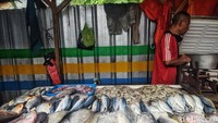 Seorang pedagang menggelar dagangannya di depan pagar pembatas Pasar Blok A yang akan direvitalisasi.
