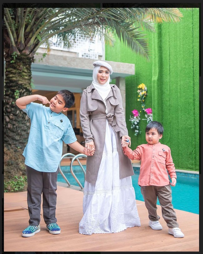 Memadukan hijab dengan topi baret adalah salah satu gaya khasnya. Padanan trench coat membuat gayanya terlihat stylish. (Foto: Instagram/@apriljasmine28)